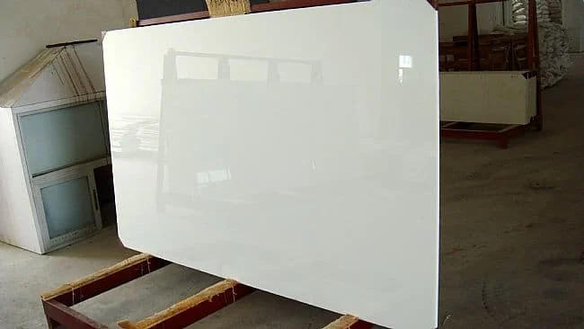 Glossy bright-white Nano White G20 crystallized-glass slab displayed in a workshop